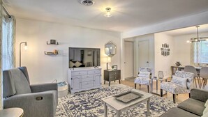 A modern living room with a grey sofa, a white cabinet, and patterned rugs. - 1 Mi to Main St: Brenham Retreat w/ Game Room (Brenham)