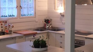 A kitchen with a central island, bar stools, a sink, and a stove.