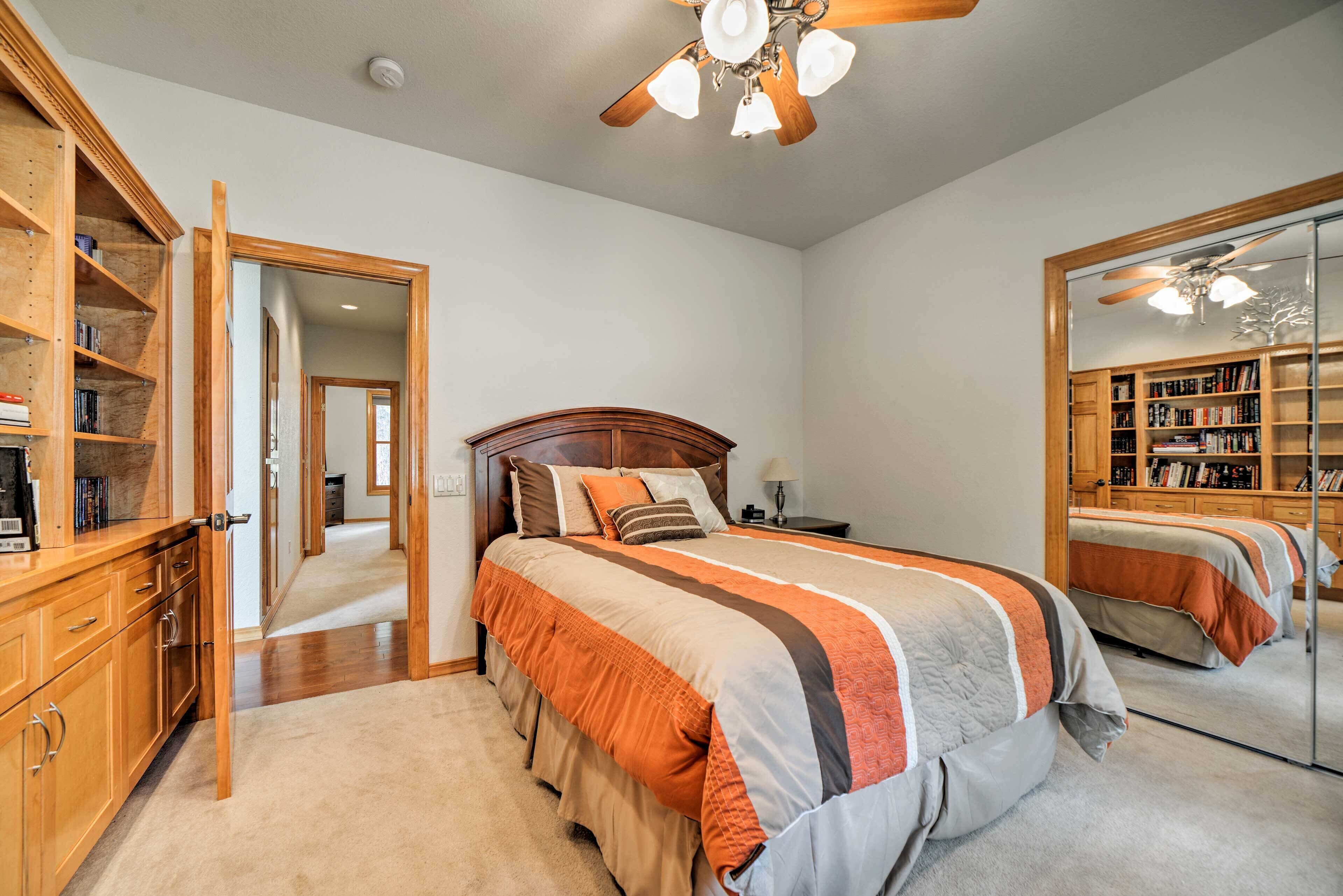 A bedroom with a large bed, wooden headboard, a wardrobe, and a mirror.