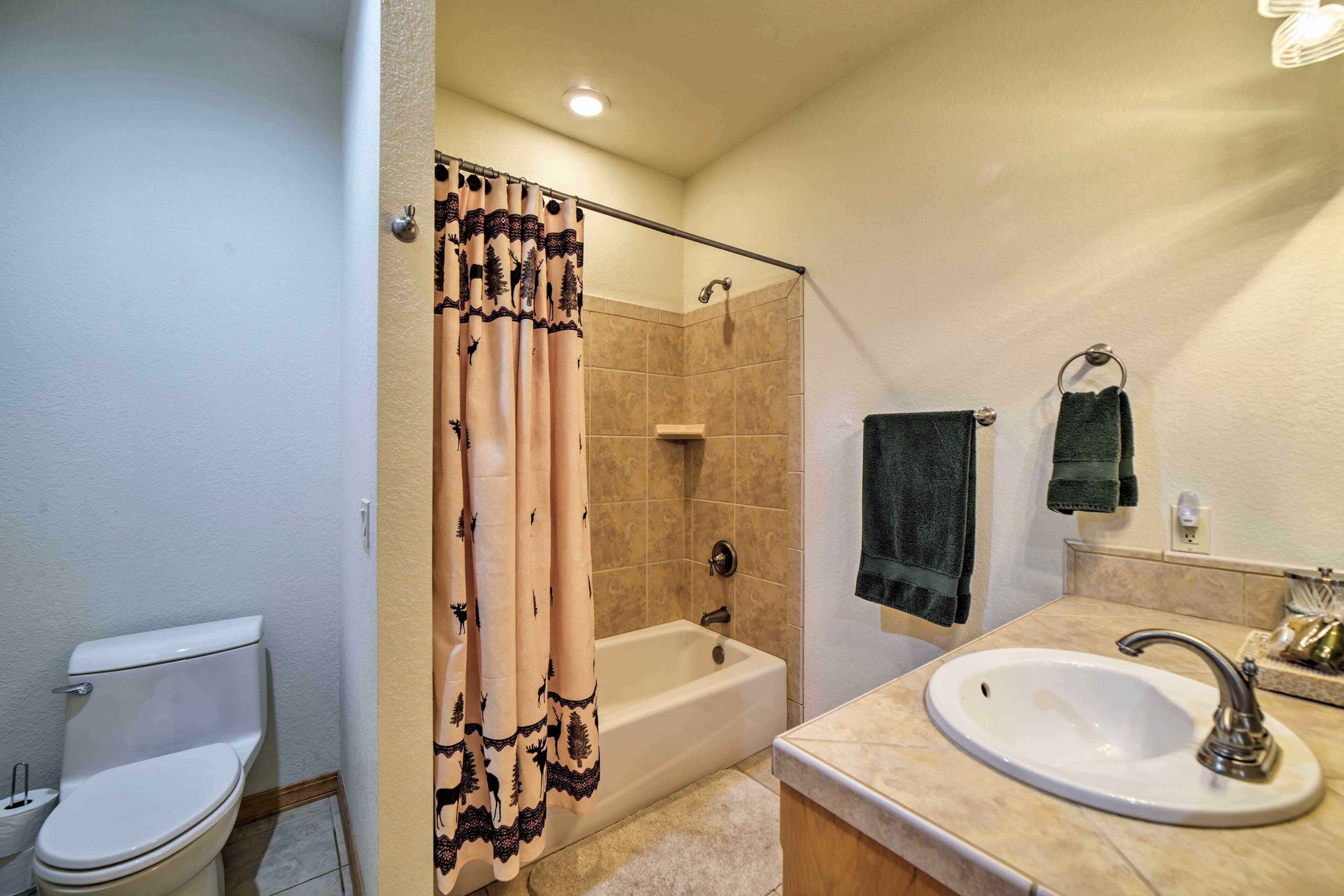 A bathroom with a toilet, a bathtub, and a sink.