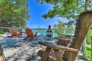 A wooden deck with Adirondack chairs and a lantern, overlooking a lake. - Lakefront Brownwood Home w/ Private Boat Dock (Brownwood)