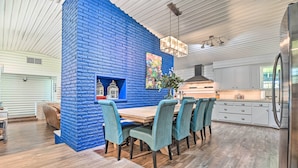 A modern kitchen with white cabinets, a stainless steel refrigerator, and a blue accent wall. - Lakefront Brownwood Home w/ Private Boat Dock (Brownwood)