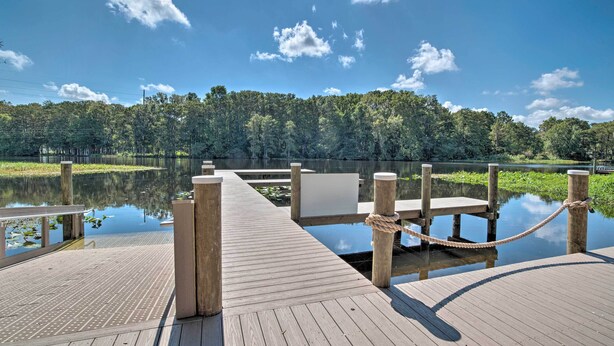 A wooden dock extending into a calm lake, surrounded by dense trees and clear skies. - Riverfront Apt w/ Kayak Launch in Dunnellon (Dunnellon)