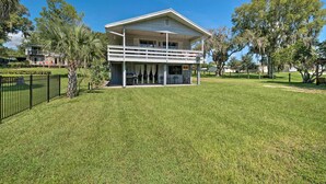 A two-story house with a balcony, surrounded by a well-maintained lawn and trees. - Riverfront Apt w/ Kayak Launch in Dunnellon (Dunnellon)