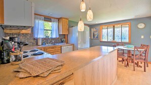 A modern kitchen with a central island, wooden cabinets, a built-in stove, and pendant lighting. - Riverfront Apt w/ Kayak Launch in Dunnellon (Dunnellon)