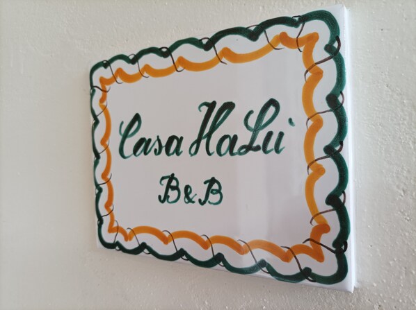A sign with the text "Casa Halui B&B" framed by a decorative border.