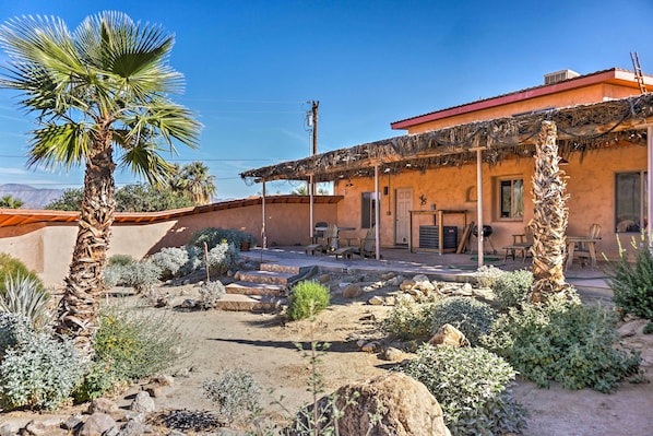 A rustic building with a patio area, outdoor seating, and a variety of desert plants. - Borrego Springs Home w/ Desert & Mountain Views! (Borrego Springs)