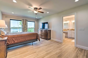 A bedroom with a bed, dresser, and a ceiling fan. - Waterfront Callaway Bayou Home w/ View & Boat Slip (Panama City)