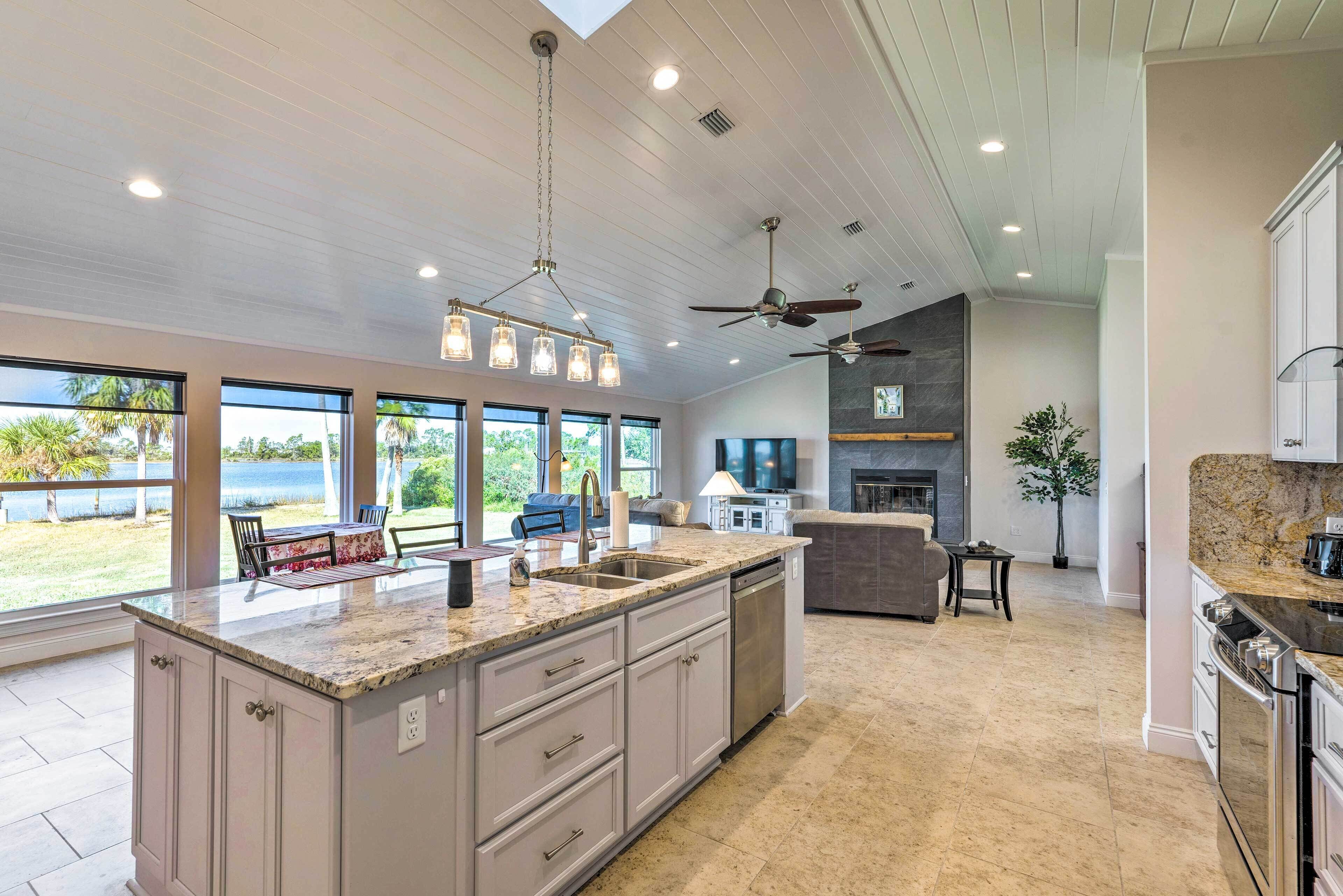 A spacious kitchen with a large island, built-in appliances, and a view of the outdoors.