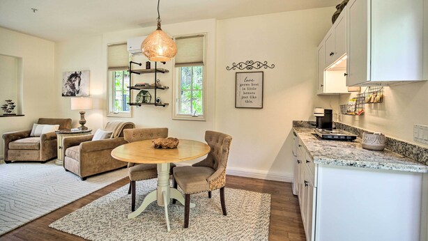 A modern kitchen with white cabinets, a granite countertop, and a hanging pendant light. - Rancho Santa Fe Casita - Gate Guarded Community! (Escondido)