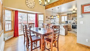 A dining area with a wooden table and chairs, a chandelier, and a clock on the wall. - Silverthorne Ski Base w/ Mtn Views: Walk to Trails (Silverthorne)