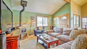 A cozy living room with a fireplace, a sofa, a coffee table, and a wooden cabinet. - Silverthorne Ski Base w/ Mtn Views: Walk to Trails (Silverthorne)