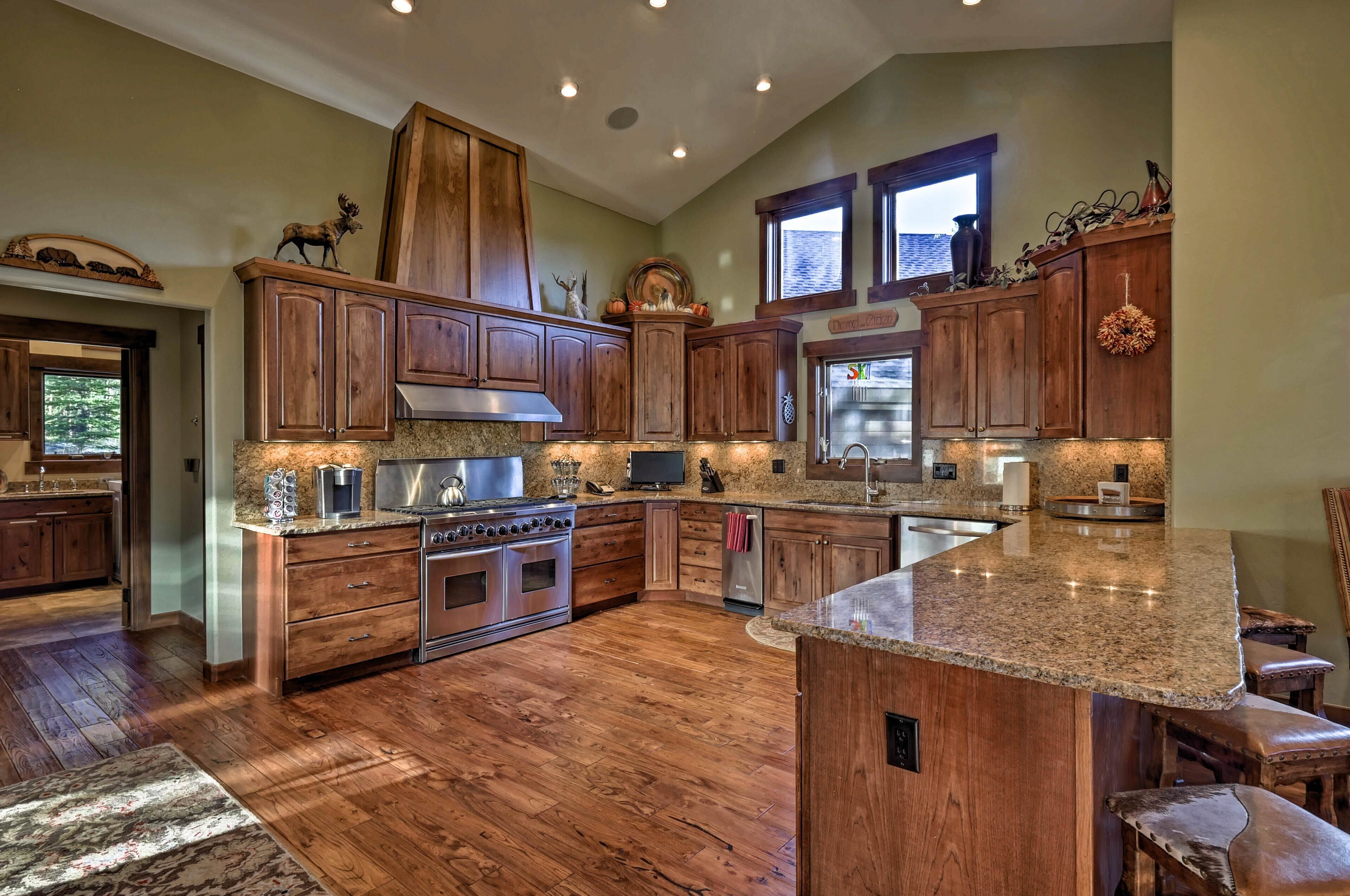 A spacious kitchen with wooden cabinets, granite countertops, and a large island.