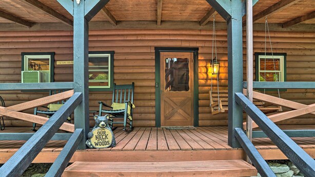 A wooden cabin with a porch, a welcome sign, and a bench. - Pocono Log Cabin: Fireplace, Fire Pits & Amenities (Pocono Lake)