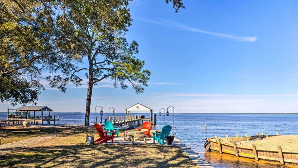 A lakeside deck with outdoor seating and a gazebo. - East Bay Vacation Rental w/ Dock! (Gulf Breeze)