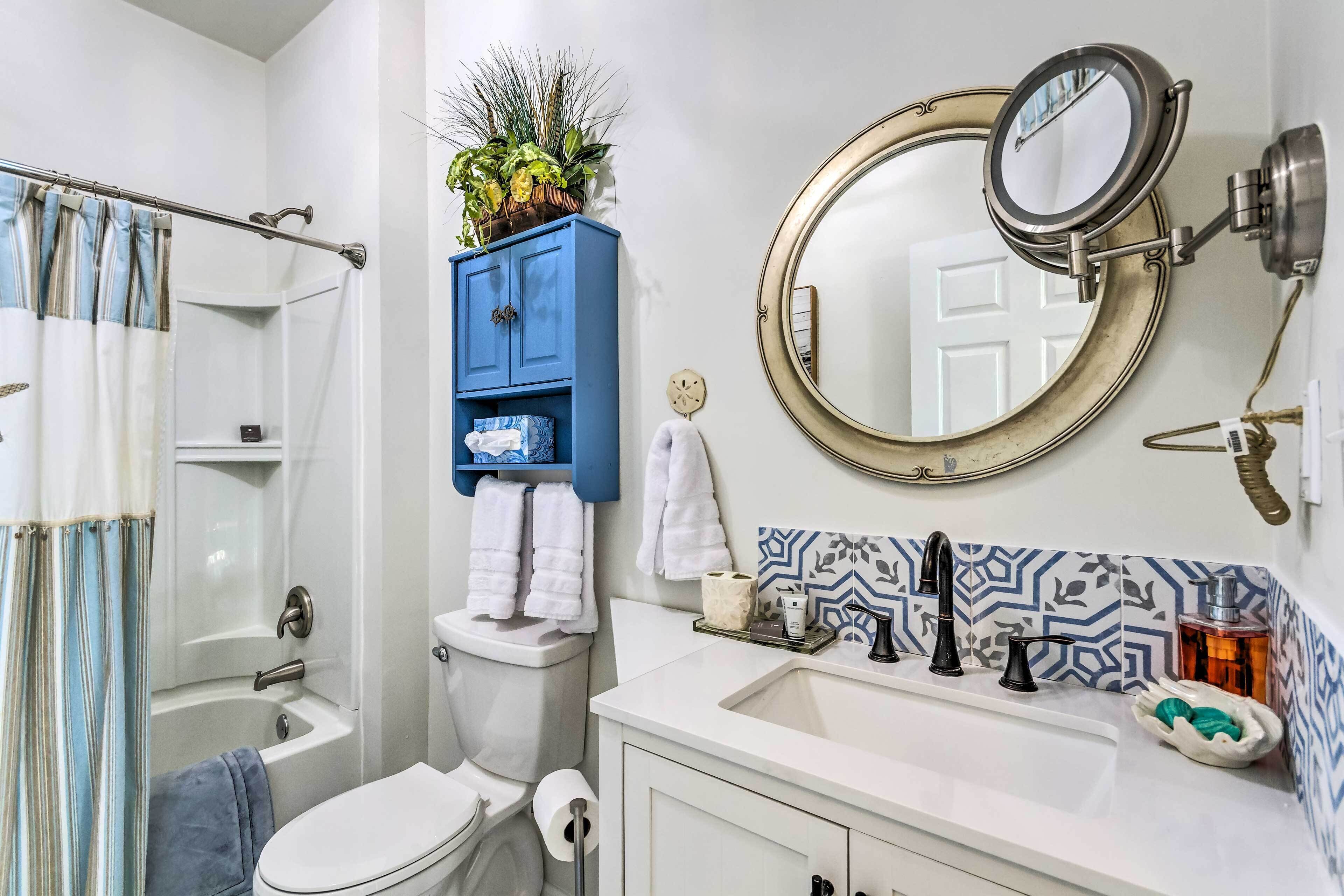 Un bagno con doccia, toilette, lavandino e un armadietto blu con asciugamani.