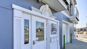 A building with a white door, a window with a view, and a sign that reads "CREATED BY". - Dtwn Ludington Condo: Balcony, Walk To Beach! (Ludington)