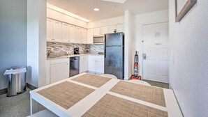 A modern kitchen with white cabinets, a black refrigerator, and a tiled backsplash. - Orlando Family Condo ~ 9 Mi to Magic Kingdom! (Orlando)