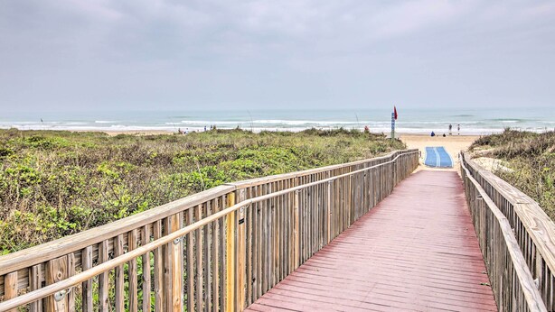 A wooden boardwalk leading to a beach with a clear view of the ocean. - Beach Digs: Walk to Restaurants, Bars & Ocean (South Padre Island)