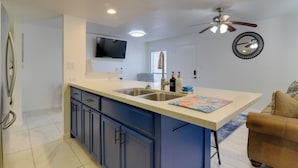 A kitchen with a large island, double sink, and a ceiling fan. - Beach Digs: Walk to Restaurants, Bars & Ocean (South Padre Island)