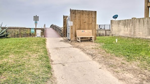 A pathway leading to a wooden structure with a bench. - Beach Digs: Walk to Restaurants, Bars & Ocean (South Padre Island)