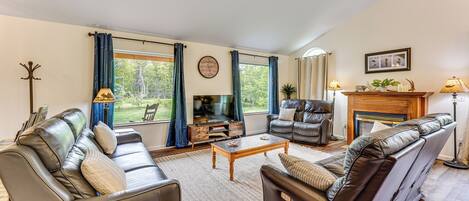 A spacious living room with a leather sofa, a wooden coffee table, and a fireplace.