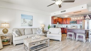 A modern kitchen with wooden cabinets, stainless steel appliances, and a bar area.