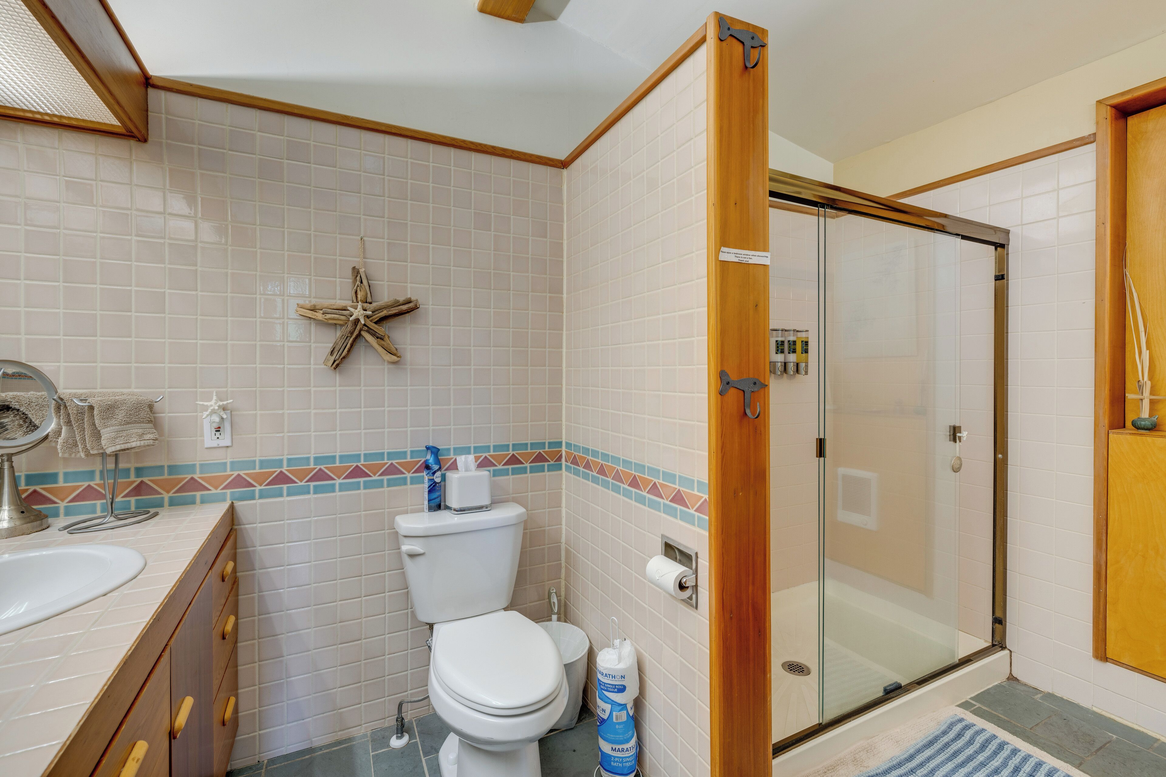 Une salle de bain avec des toilettes, un lavabo et une douche.