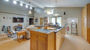 Une cuisine spacieuse avec des meubles en bois, un îlot central et des luminaires suspendus.
