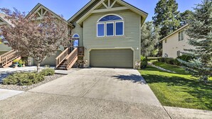 A two-story house with a front garage, a staircase leading to the entrance, and a well-maintained lawn. - Pagosa Springs Home w/ Deck & Grill, Walk to Town! (Pagosa Springs)