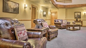 Un salon spacieux avec des canapés en cuir, une table basse et un escalier menant à un niveau supérieur.
