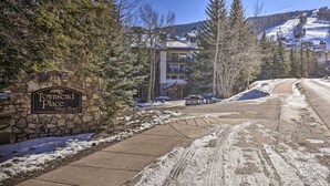 Un panneau en pierre indiquant « Townsend Place, Village Road » et un immeuble doté de nombreux balcons.
