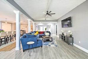 A spacious living room with a sectional sofa, a coffee table, and a TV mounted on the wall. - Vibrant Terrytown Home w/ Yard ~ 6 Mi to Nola (Gretna)