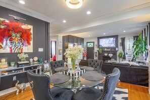 A modern living room with a glass coffee table, dark sofas, and a fireplace. - Butterfly Place-near Johns Hopkins,pimlico,stadium (Baltimore)