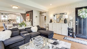 A modern living room with a grey sectional sofa, a glass coffee table, and a black and white rug. - Butterfly Place-near Johns Hopkins,pimlico,stadium (Baltimore)