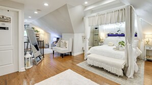 A bedroom with a large bed, a sitting area, and a view of the city. - Butterfly Place-near Johns Hopkins,pimlico,stadium (Baltimore)