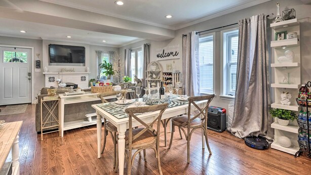 A well-lit dining area with a chandelier, a television above the counter, and a 'welcome' sign on the wall. - Butterfly Place-near Johns Hopkins,pimlico,stadium (Baltimore)