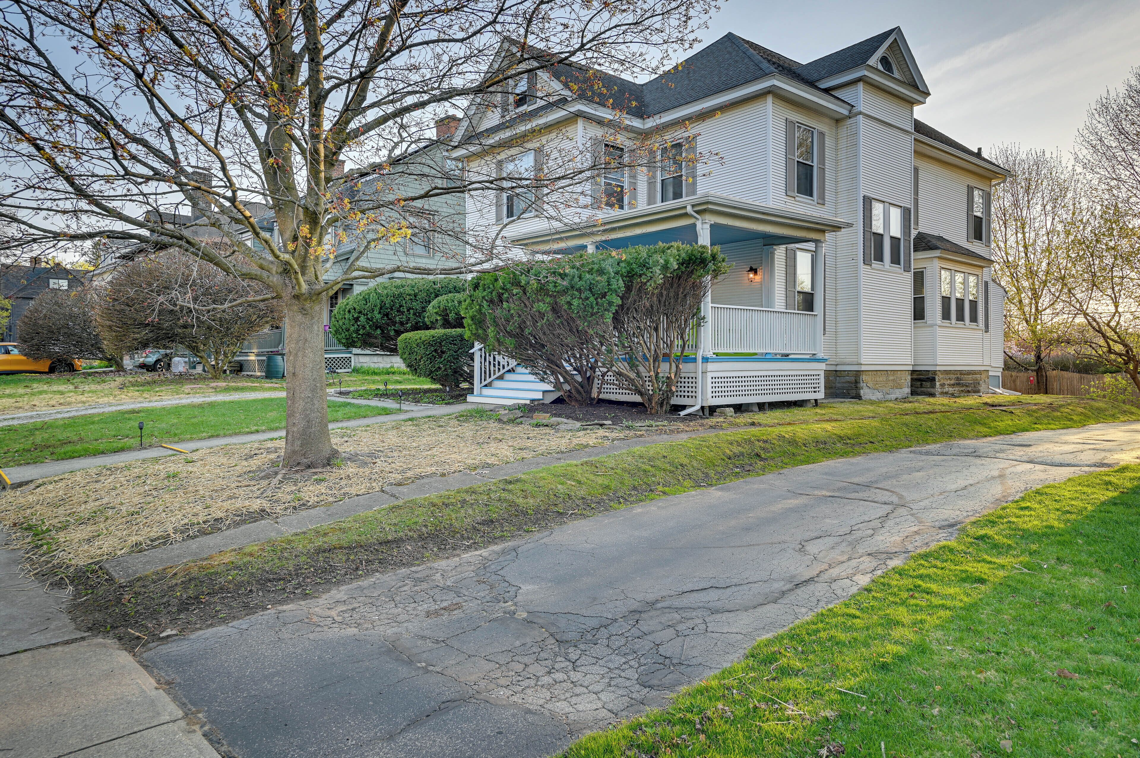 A two-story house with a front porch, a driveway, and a lawn.
