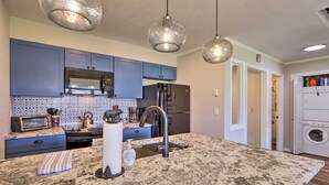 A modern kitchen with blue cabinets, a stainless steel refrigerator, a built-in oven, and a granite countertop. - Peaceful Pagosa Springs Escape ~ 2 Mi to Lake (Pagosa Springs)