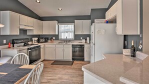 A modern kitchen with white cabinets, a gas stove, a dishwasher, and a refrigerator. - 7 Mi to Wdw: Indian Ridge Home + Community Perks! (Kissimmee)