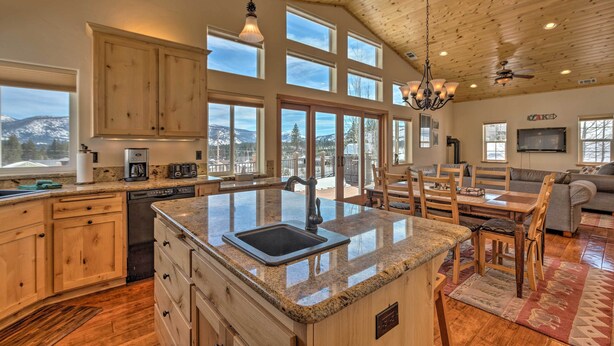 A spacious kitchen with granite countertops, wooden cabinets, and a large island with a sink. - Mountain-view Deck: South Lake Tahoe Retreat! (South Lake Tahoe)