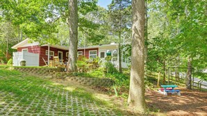A mobile home with a patio area, surrounded by trees and a paved walkway. - Walk to Beach: Long Island Wine Country Home! (Cutchogue)