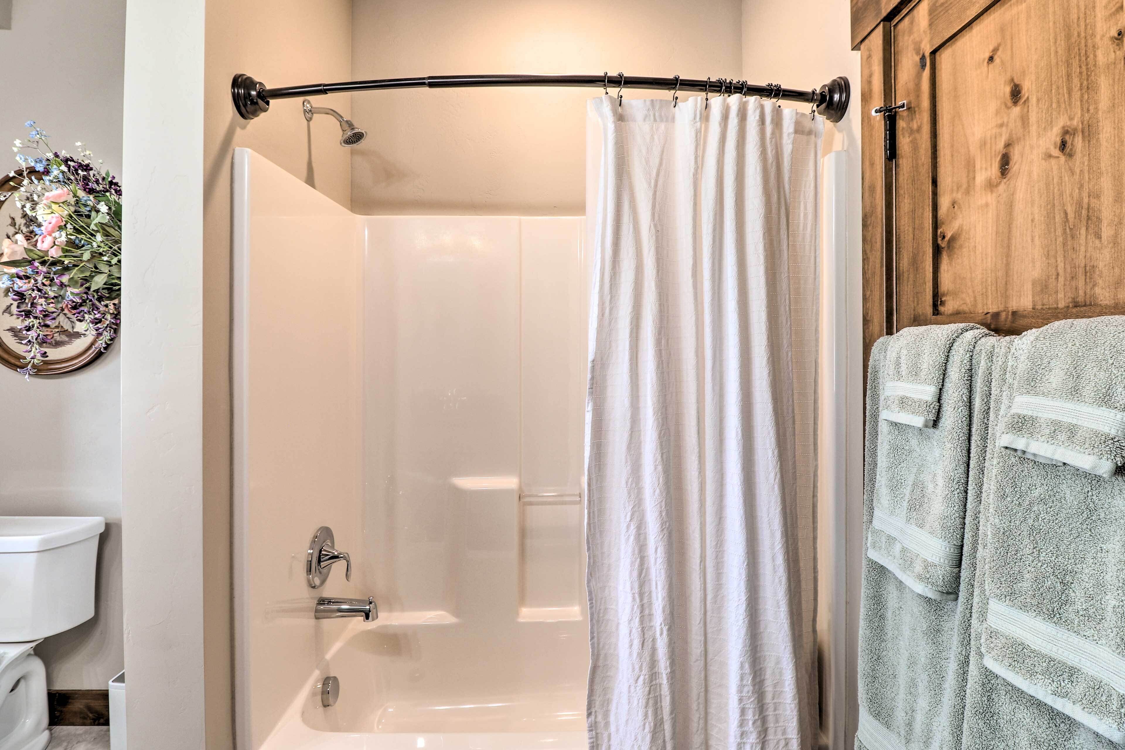 Une salle de bain avec une baignoire, un rideau de douche et un porte-serviettes.