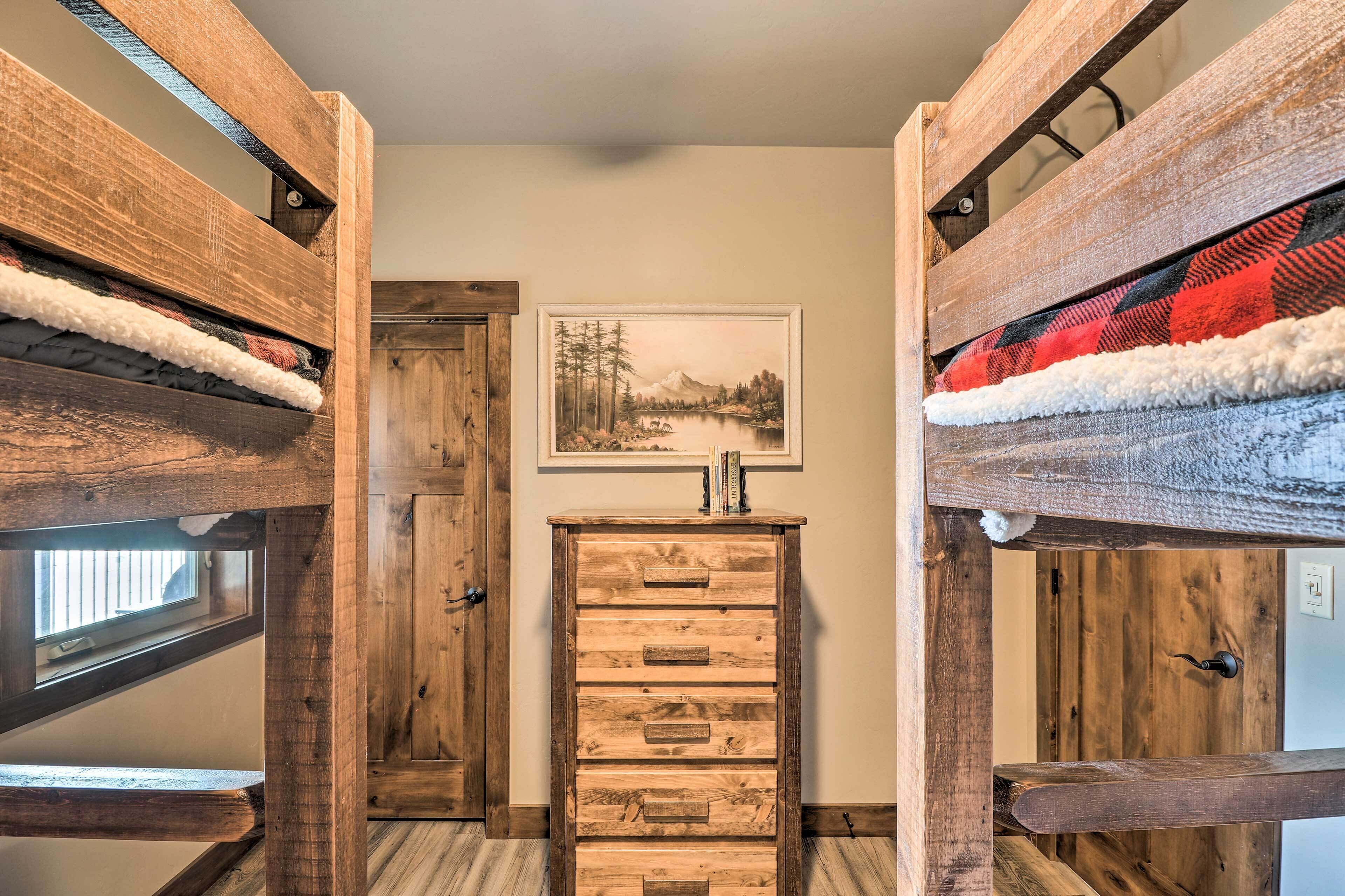Una camera in legno rustica con un letto a soppalco, un comò di legno e un dipinto di un paesaggio appeso al muro.