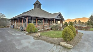 A building with a prominent tower, large windows, and a covered porch area. - Walk to Ski & Golf: Sugar Mountain Condo! (Banner Elk)