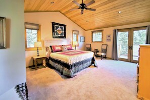 A bedroom with a large bed, a ceiling fan, and multiple windows. - Hot Tub & Lake Tahoe Views: Kings Beach Lodge (Kings Beach)
