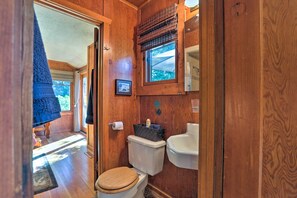 A compact wooden bathroom with a toilet, sink, and window. - Hot Tub & Lake Tahoe Views: Kings Beach Lodge (Kings Beach)