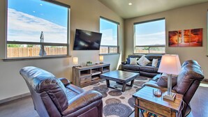 A spacious living room with leather sofas, a coffee table, and a flat-screen TV mounted on the wall. - Upscale Moab Townhome w/ Hot Tub: 20 Min to Arches (Moab)