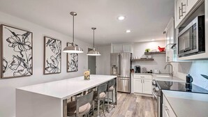 Una cocina moderna con una isla central, electrodomésticos de acero inoxidable y decoración contemporánea.
