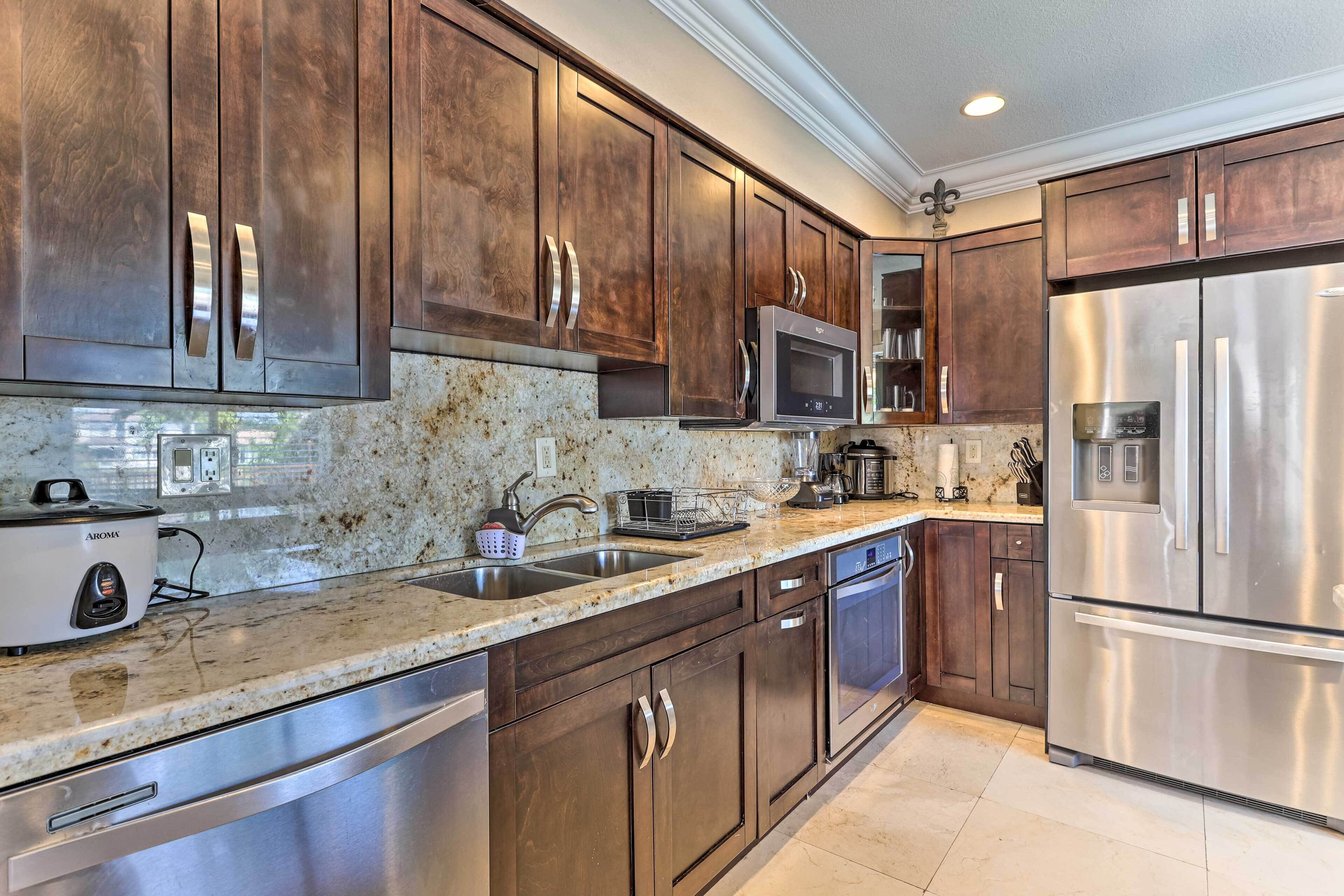 A kitchen with dark wooden cabinets, stainless steel appliances, and granite countertops.